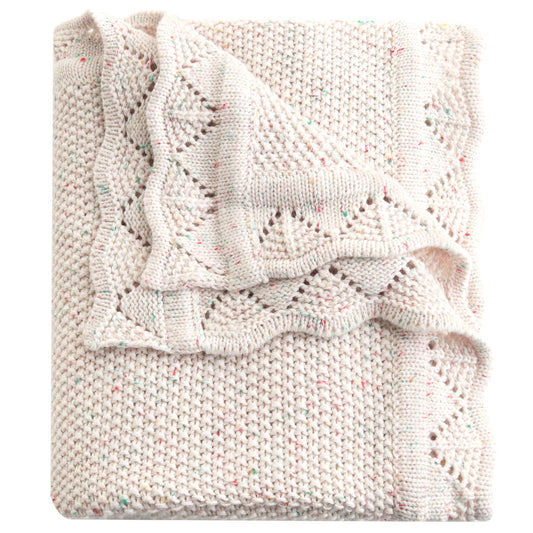 Folded knitted blanket with a subtle pattern on a white background