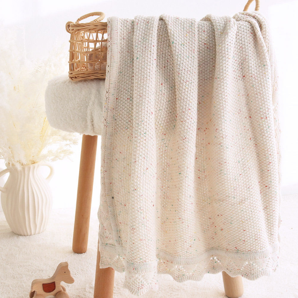 Textured blanket draped over a chair with a wicker basket and decorative items in the background.